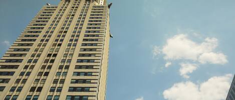 Un edificio alto con una aguja distintiva y numerosas ventanas.