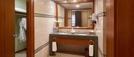 A modern bathroom with a double sink vanity, a large mirror, and a towel rack.