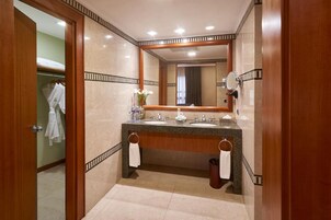 Un baño moderno con tocador doble, un espejo grande y un perchero para toallas.