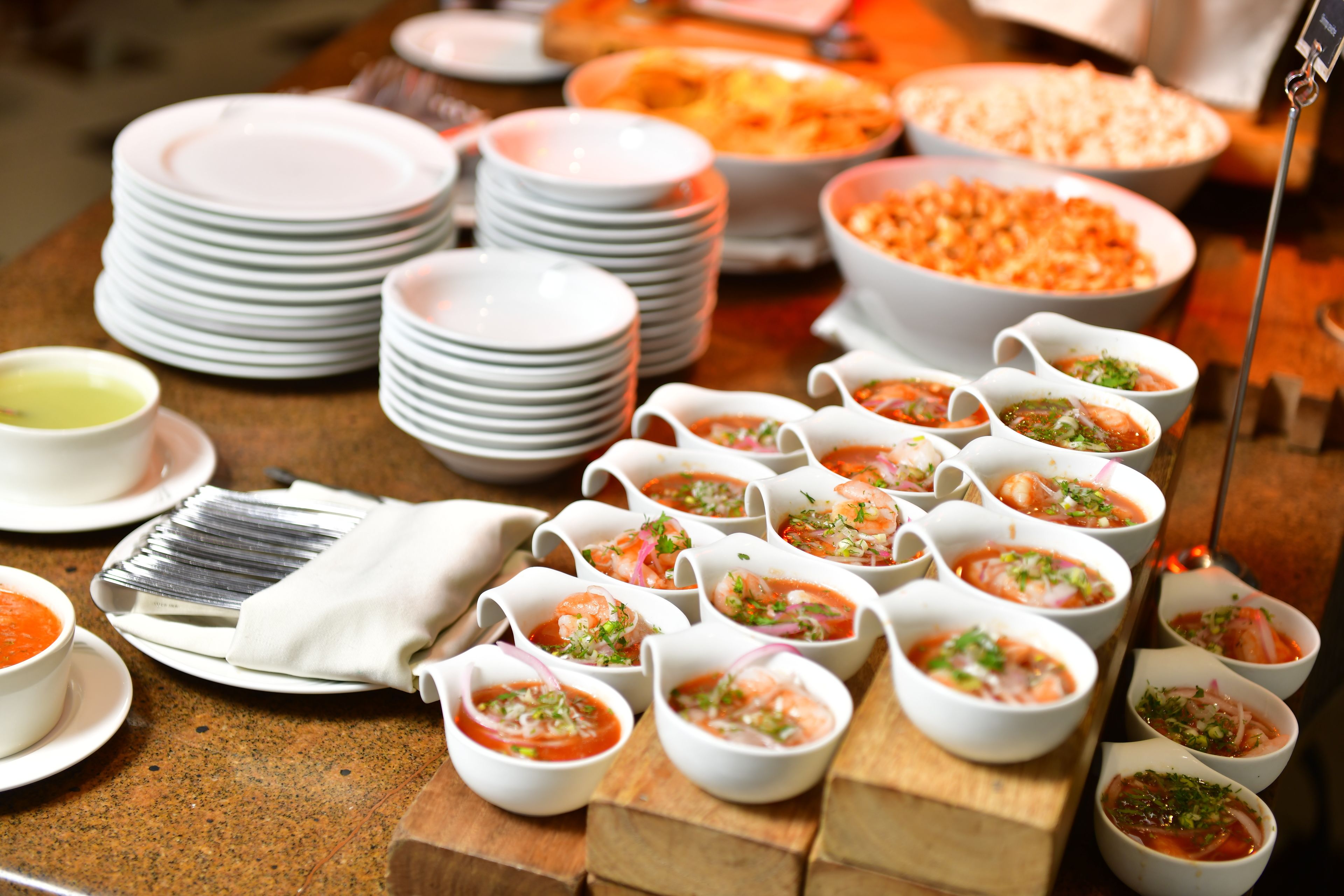 A buffet table with various dishes and bowls of food, including seafood and salads.
