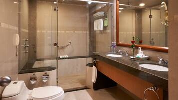 A modern bathroom with a glass-enclosed shower, two sinks, and a large mirror.