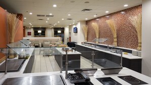 Una cocina moderna con electrodomésticos de acero inoxidable, un separador de vidrio y un salpicadero de azulejos.