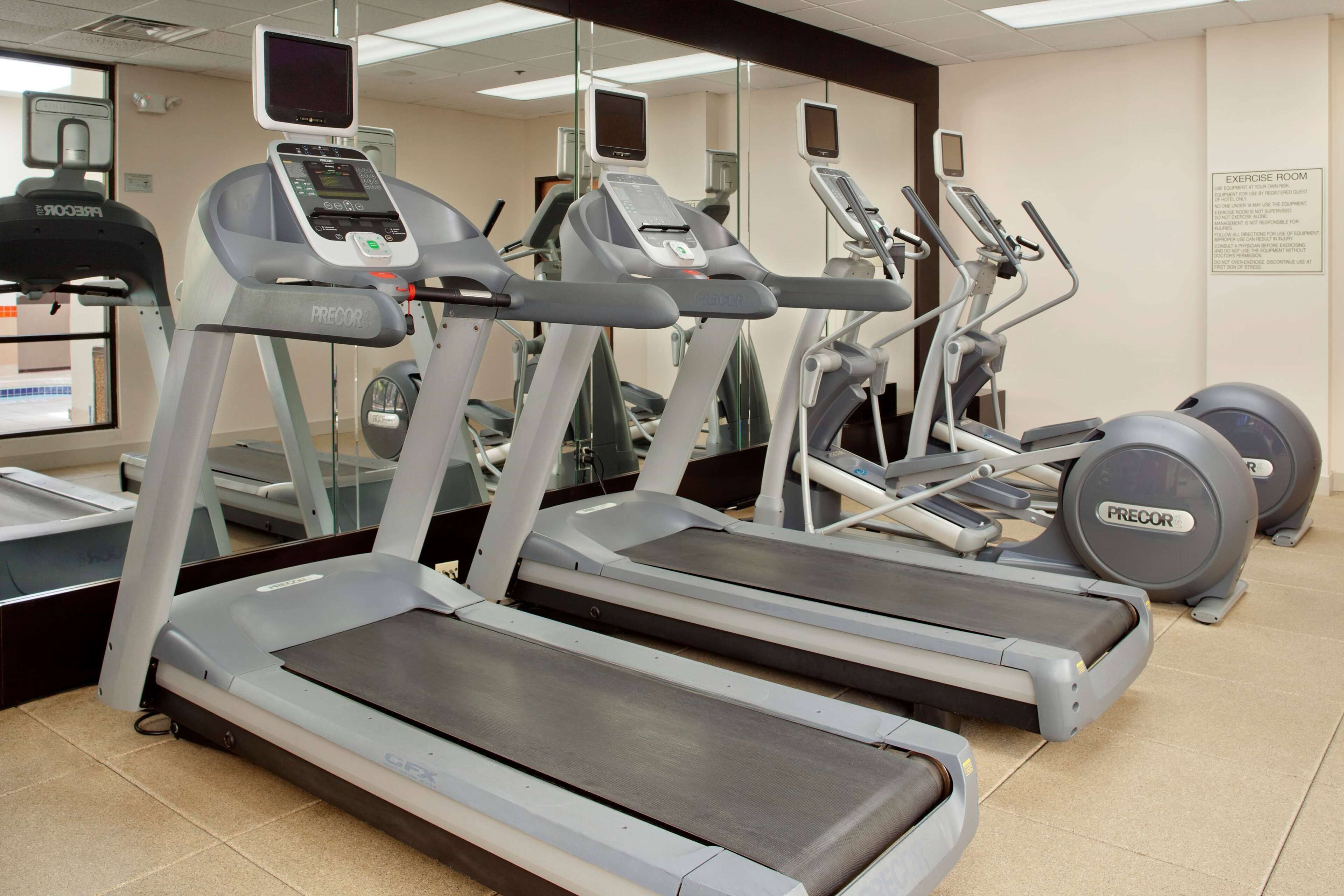 A gym with treadmills, ellipticals, and exercise balls.