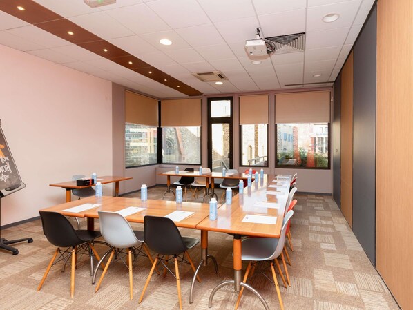 A conference room with a long table, multiple chairs, and a projector.