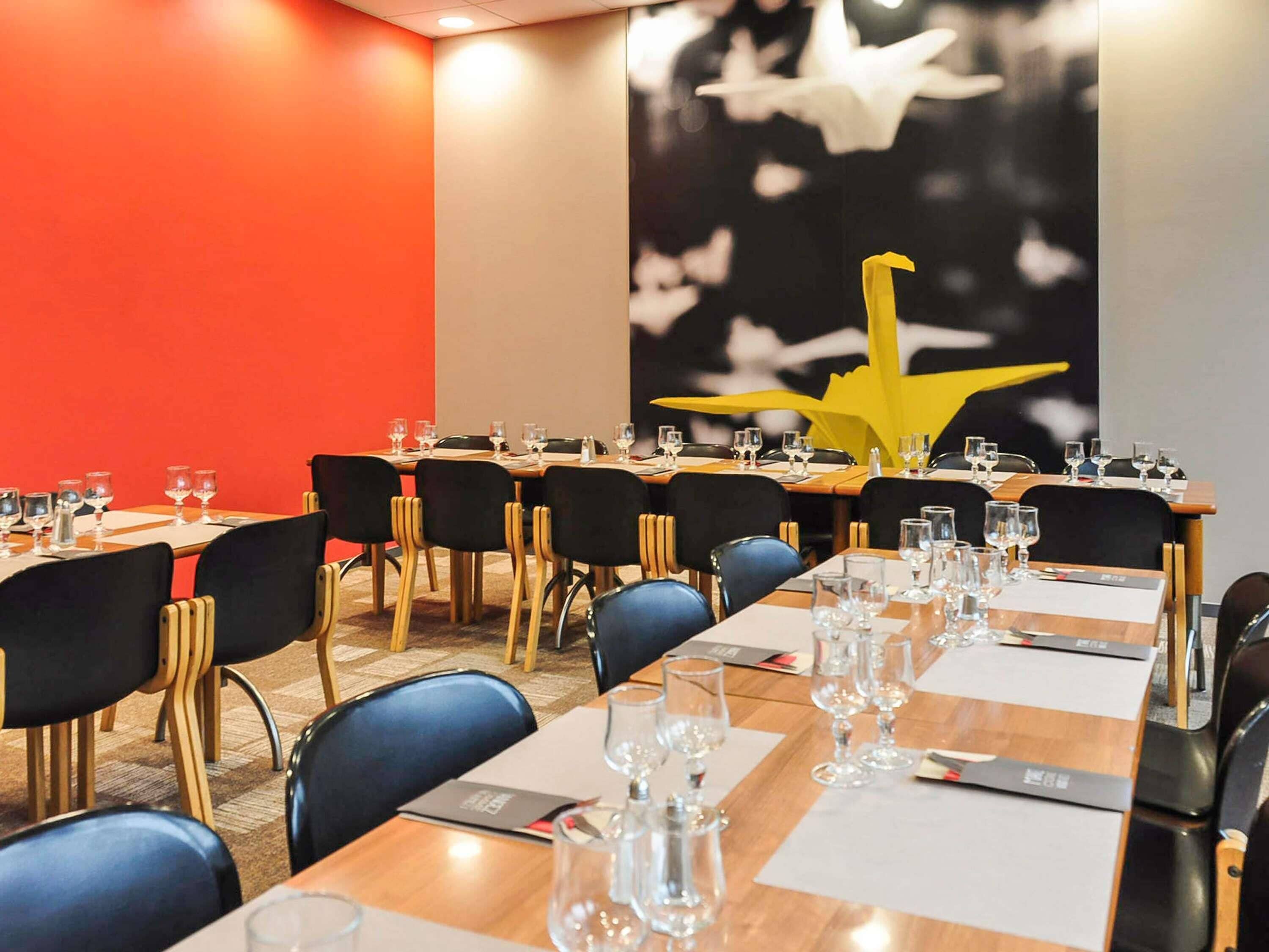 A conference room with tables set for meetings, equipped with chairs and glassware.