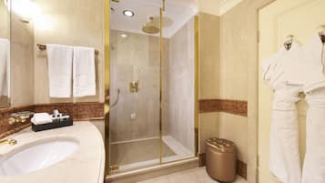 Un baño moderno con un lavamanos grande, ducha con mampara de vidrio y espejo con toallero.