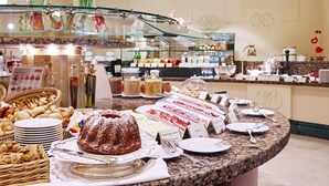 Un buffet proposant une variété de plats, notamment des pâtisseries, des viandes et des desserts.