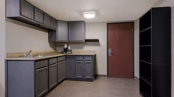 A compact kitchen with grey cabinets, a countertop, and a coffee maker.
