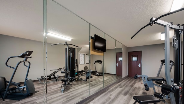 A gym with exercise equipment, a television, and a mirror. - SureStay Plus Hotel by Best Western San Antonio North (San Antonio)
