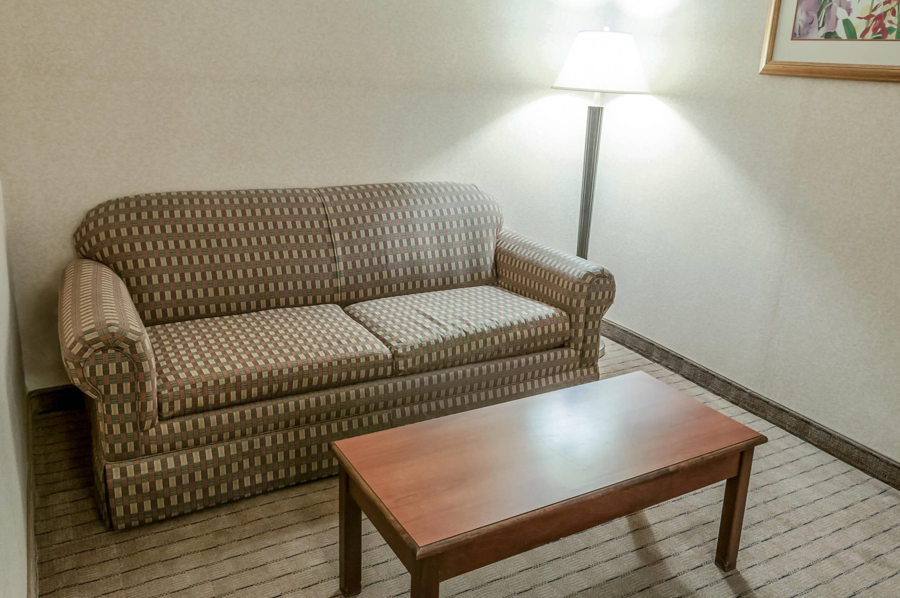 A room with a patterned sofa and a wooden coffee table.