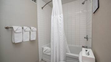 A bathroom with a shower, toilet, and towel rack.