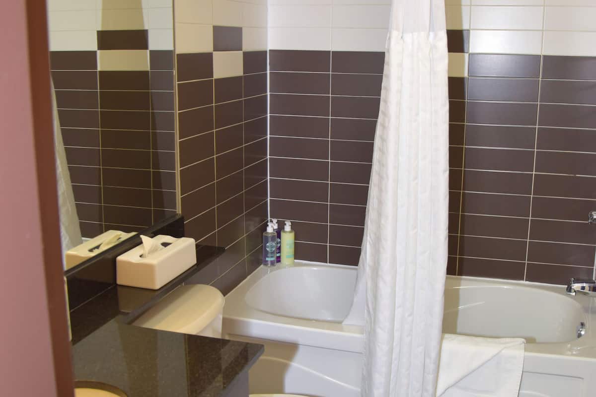 room, 1 queen bed (coast limited queen) | bathroom | bathtub, eco-friendly toiletries, hair dryer, towels