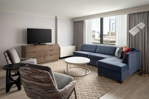 A modern living room with a flat-screen TV, a sofa, a chair, and a coffee table. - Baltimore Marriott Inner Harbor at Camden Yards (Baltimore)