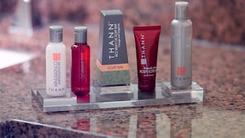 A display of THANN body care products on a clear acrylic stand.