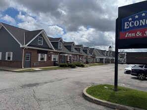 A row of brick buildings with 'OFFICE' signs, a parking lot, and a sign for 'ECON Inn & Suites'.