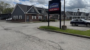 A building with a sign for 'Economy Inn & Suites' and multiple office signs. - Economy Inn North Randall (North Randall)