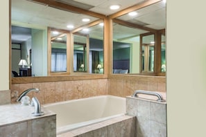 A modern bathroom with a large bathtub, a double sink, and a large mirror above the vanity. - Days Inn by Wyndham Midland (Midland)