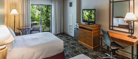 A hotel room with a bed, a desk, a chair, a television, and a window with curtains.