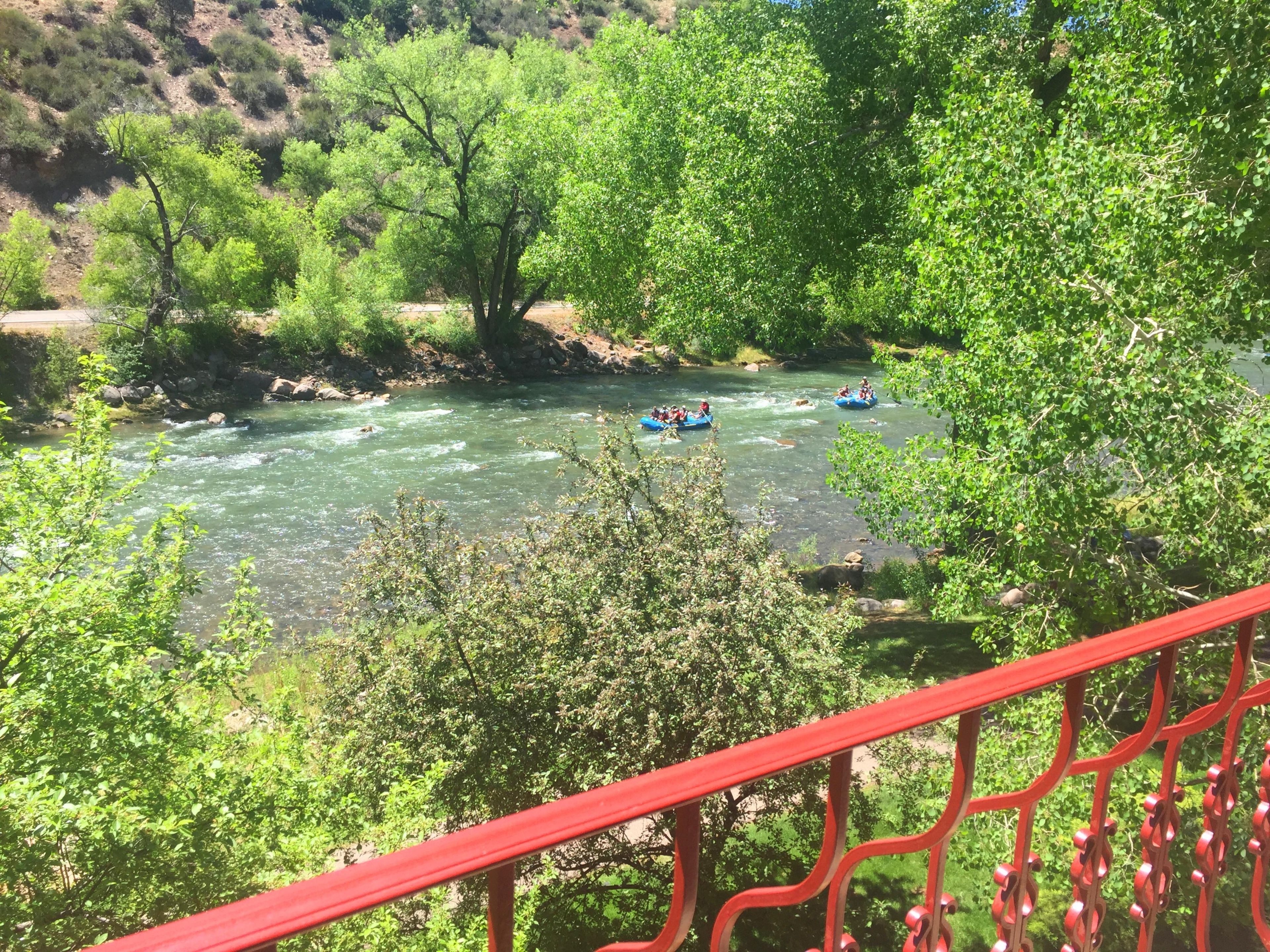 Une rivière où l’on peut faire du rafting, bordée de verdure et d’une rambarde rouge.