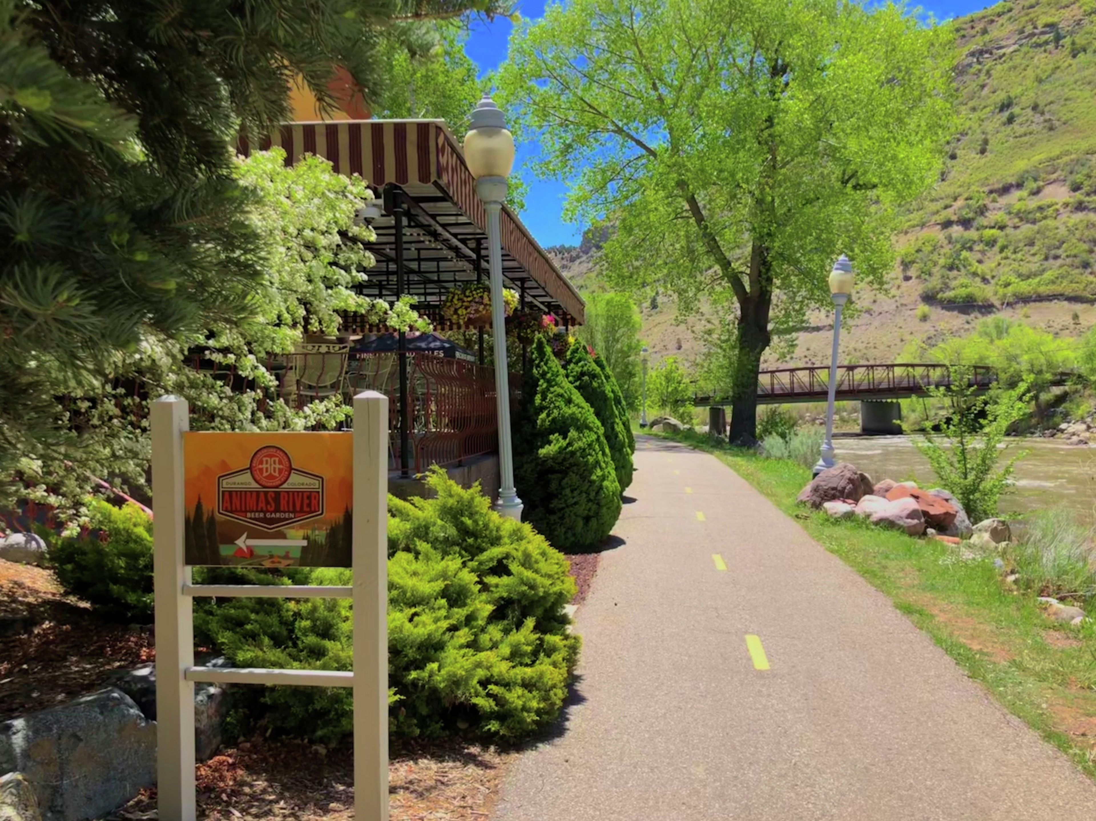 A paved path with a sign for Animas River Beer Garden.