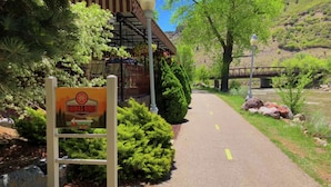 A sign for Animas River Beer Garden with a pathway leading to a building with a red and white striped awning.