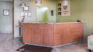 A reception area with a wooden counter, framed certificates, and a 'Comfort Inn' sign. - Comfort Inn Brockville (Brockville)