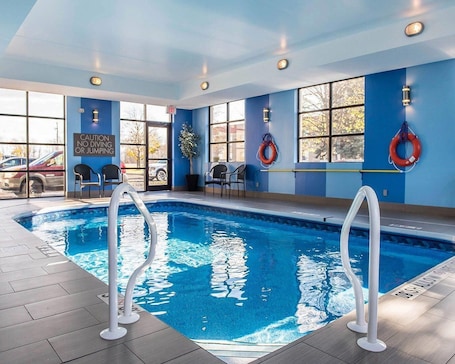 An indoor swimming pool with clear water, surrounded by blue walls and windows.. Comfort Inn Brockville