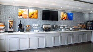 A modern breakfast bar with a flat-screen TV, a coffee machine, and a variety of food items. - Comfort Inn & Suites Coralville - Iowa City near Iowa River Landing (Coralville)