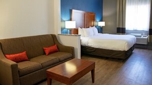 A hotel room with a bed, a sofa, a coffee table, and two bedside lamps. - Comfort Inn & Suites Coralville - Iowa City near Iowa River Landing (Coralville)