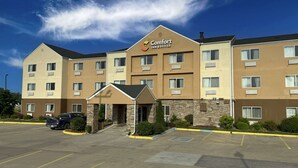 A Comfort Inn & Suites hotel with a stone facade, multiple windows, and a parking lot. - Comfort Inn & Suites Coralville - Iowa City near Iowa River Landing (Coralville)