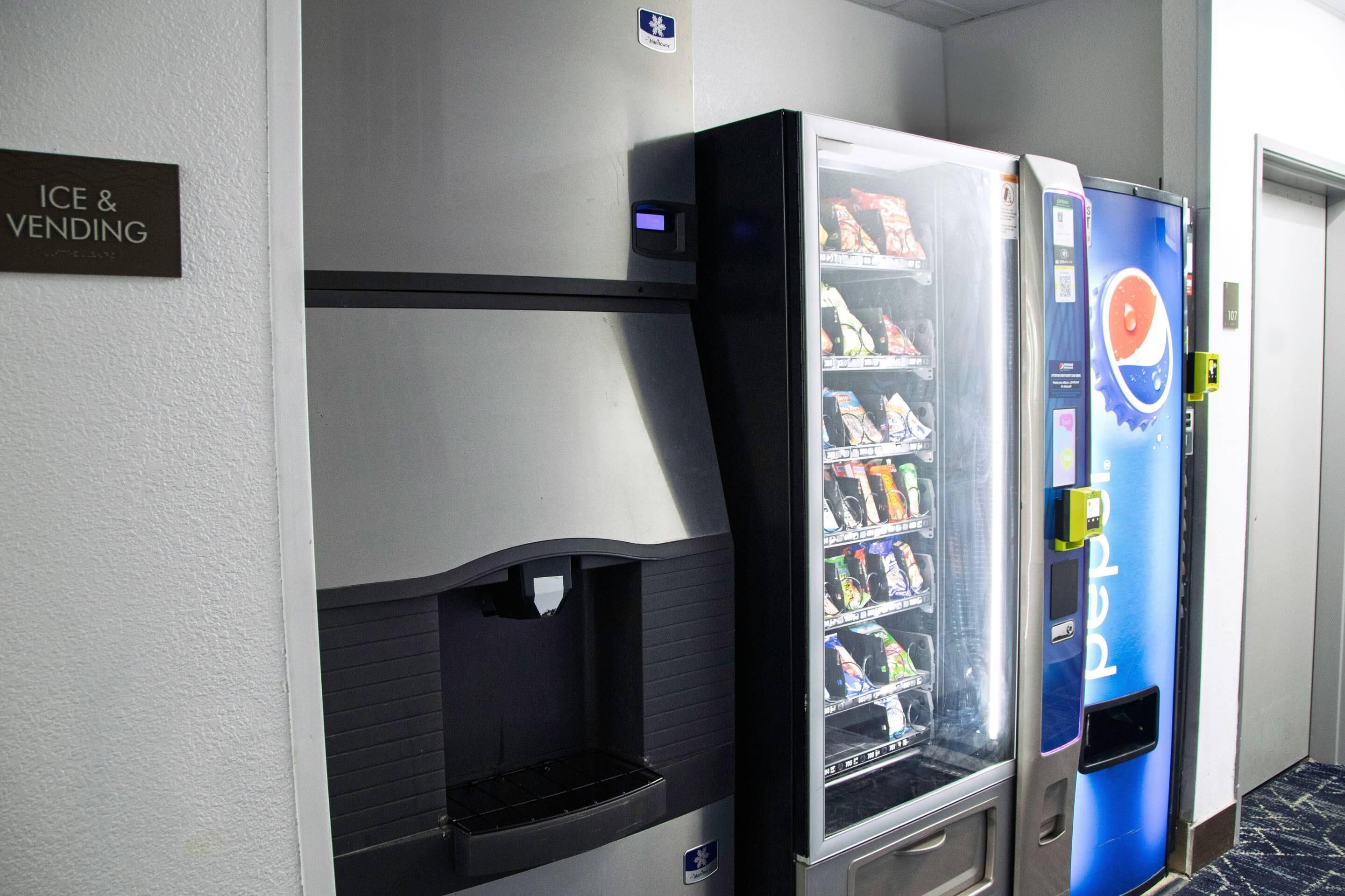 Un espace équipé d’un distributeur automatique de boissons, notamment de Pepsi, ainsi que d’un autre distributeur de boissons et de glaçons.
