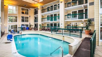 A large indoor swimming pool with a 3ft depth marker, surrounded by lounge areas and multiple balconies.