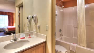 A bathroom with a sink, mirror, and a bathtub.