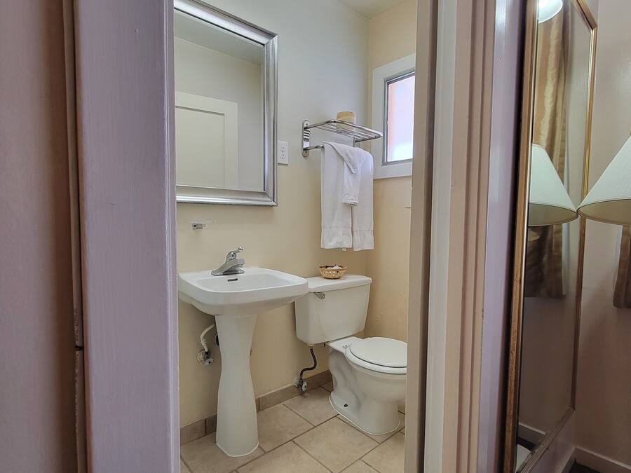A bathroom with a sink, toilet, and a mirror.