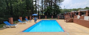 Una piscina al aire libre de temporada, sombrillas