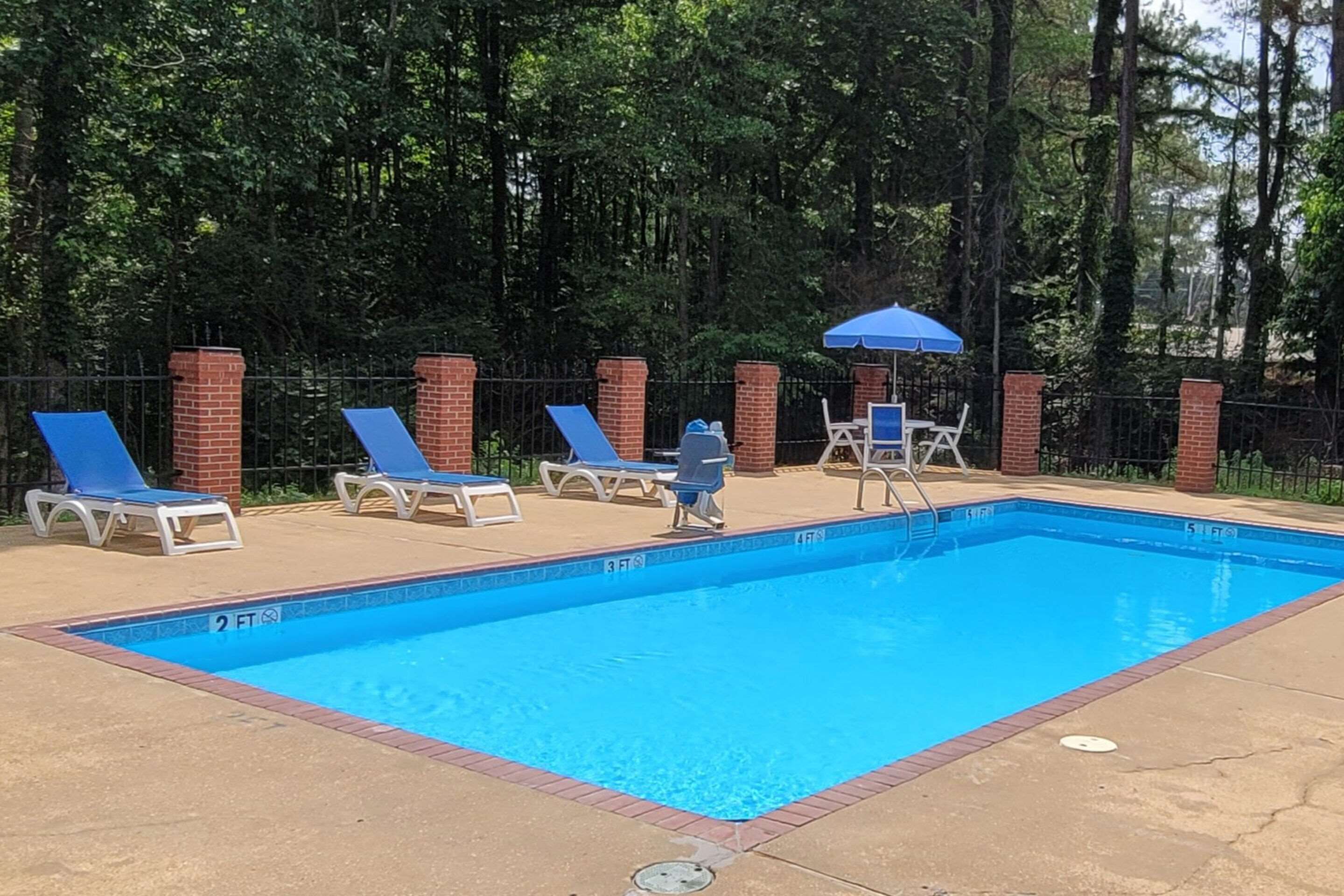 Una piscina con sillas de descanso y una zona cubierta.