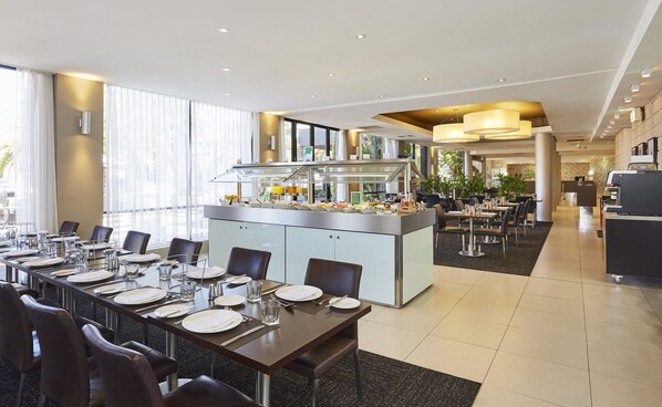 Un comedor moderno con bufé, asientos cómodos y vistas al exterior.