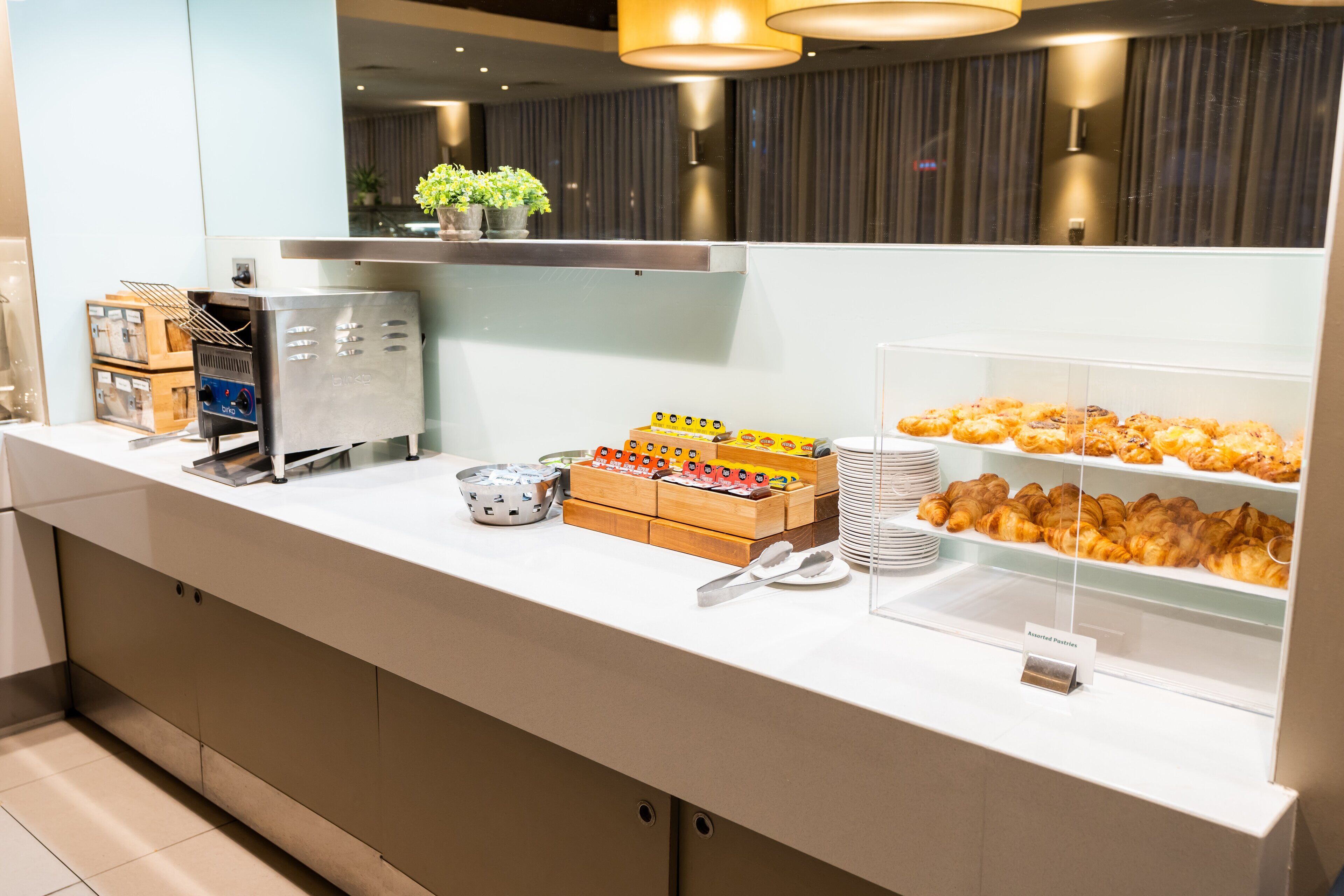 Een buffet met diverse gerechten, waaronder gebak en een koffieapparaat.