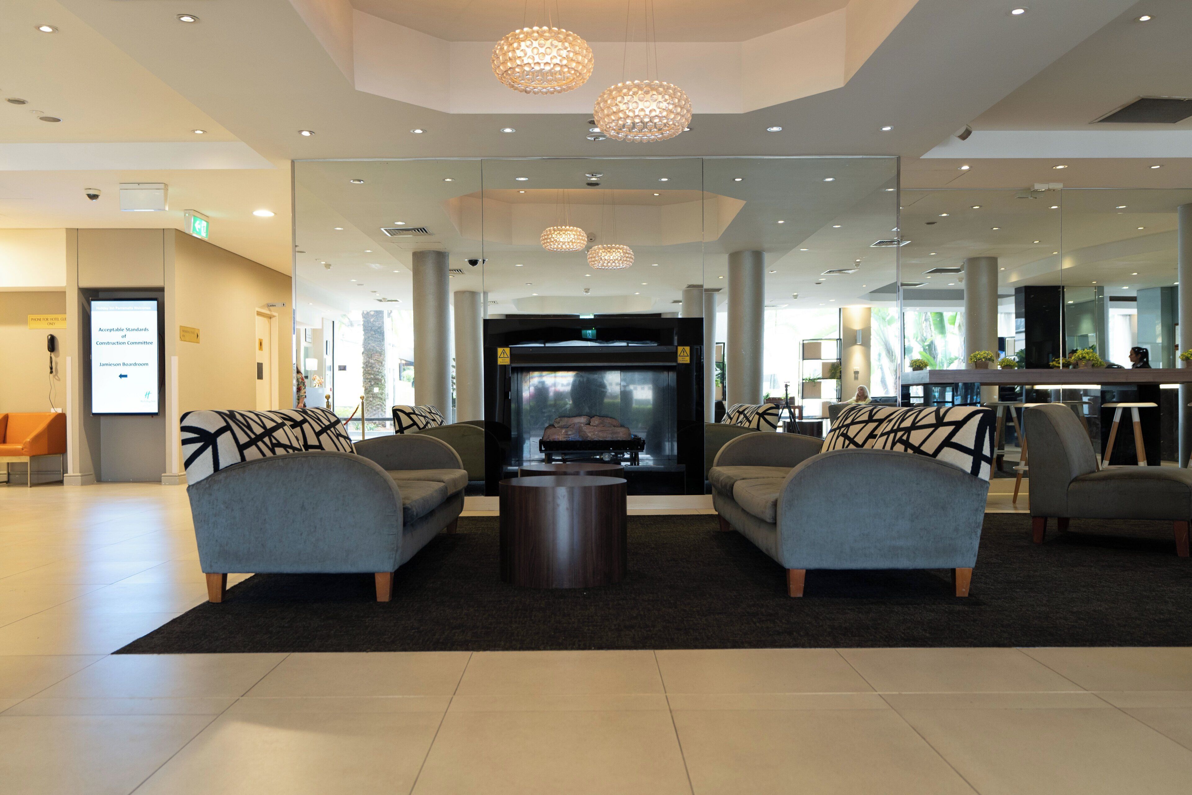 A lobby with a reception desk, seating area, and a fireplace.