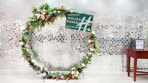 Een decoratieve krans met een bord waarop staat: 'Welcome to Holiday Inn Parramatta' en een QR-code om te taggen op sociale media.