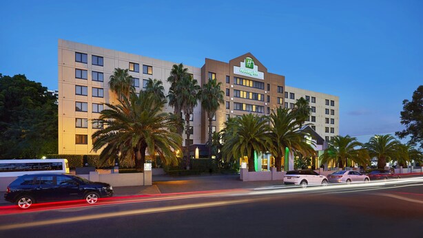 Een Holiday Inn hotel met een modern design, meerdere verdiepingen en een opvallend logo.