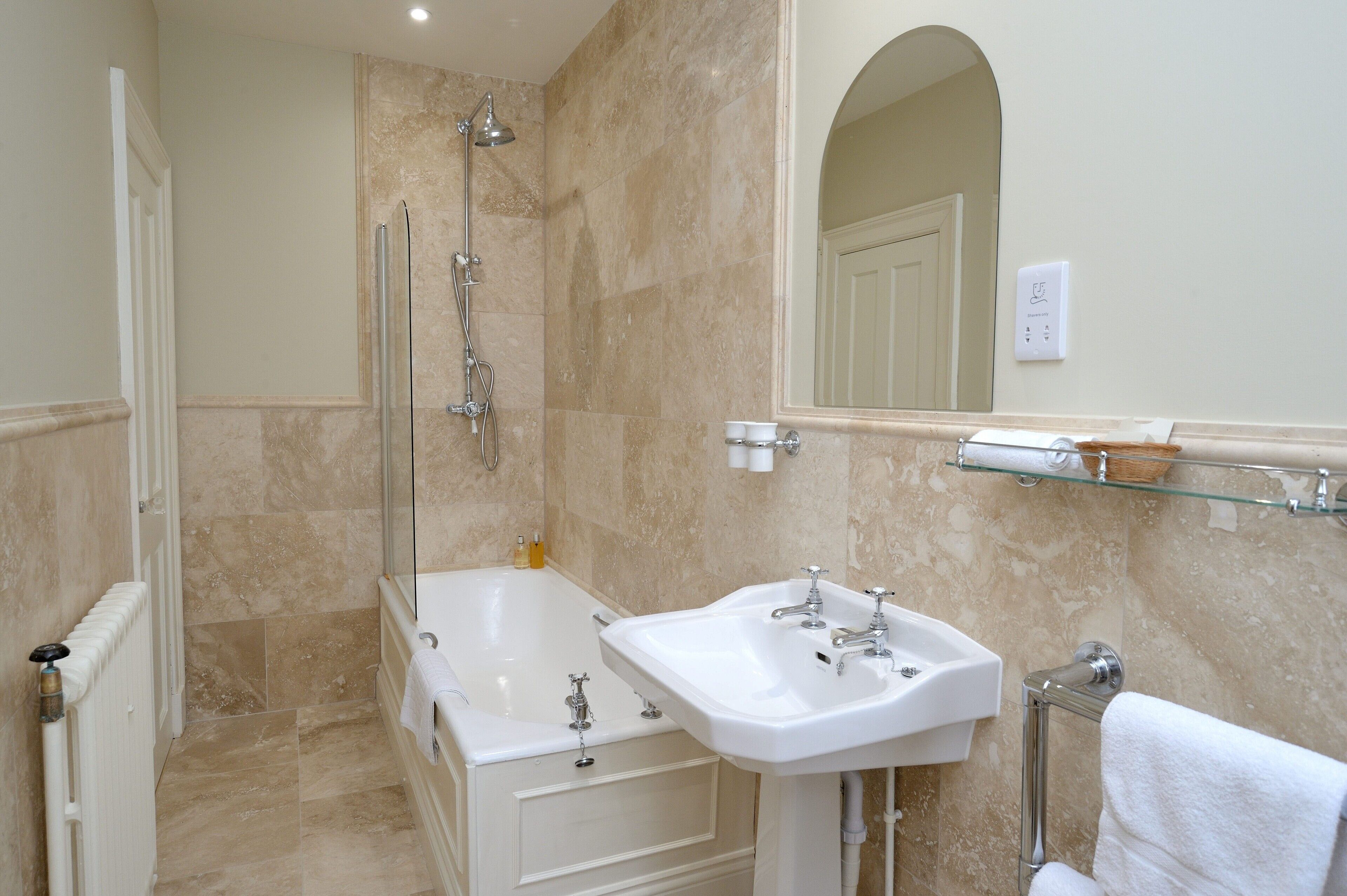 A bathroom with a bathtub, a sink, and a shower.