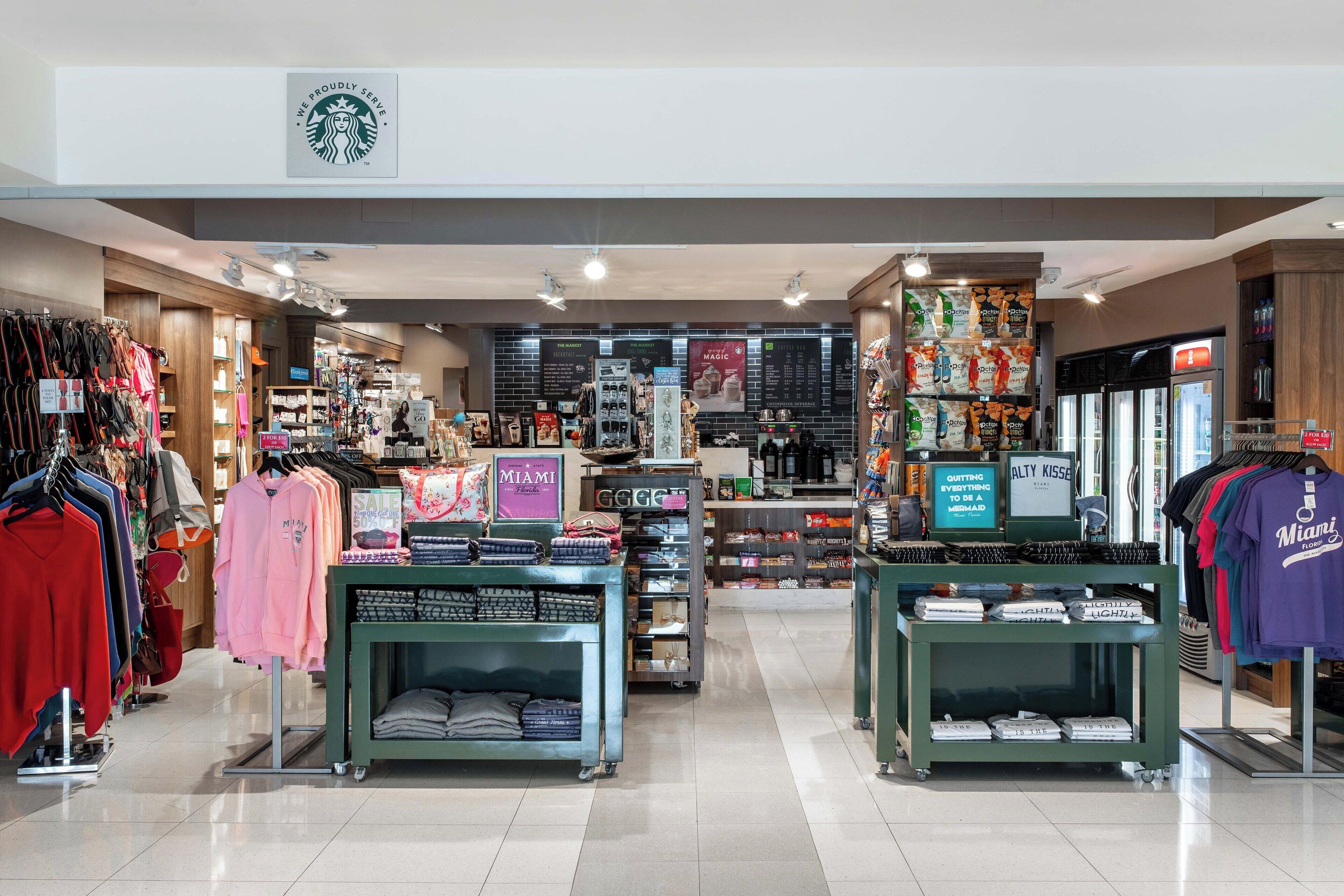 A retail store with various clothing items on display, including a section with Miami-themed merchandise.