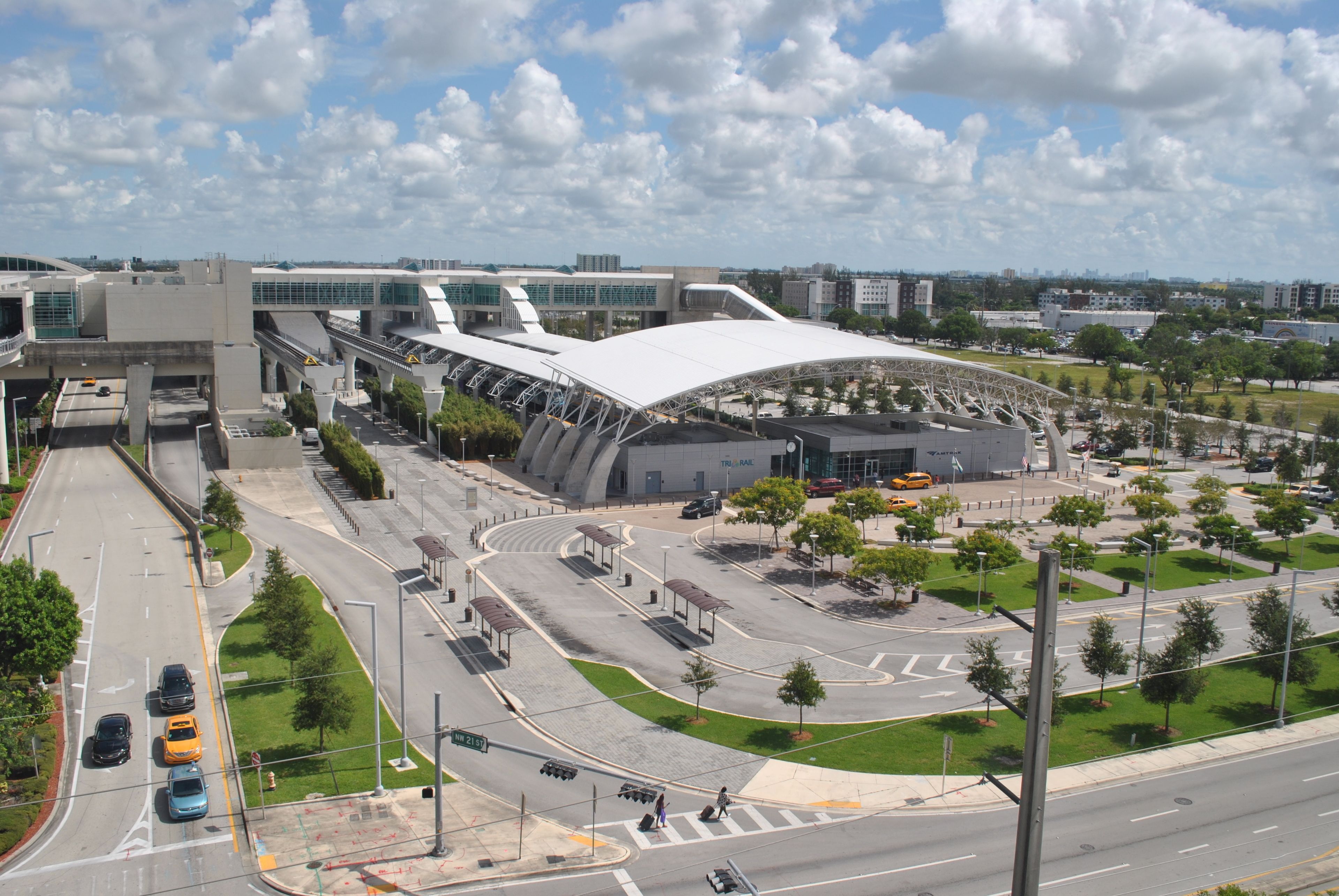 A modern building with a curved roof and a parking area with multiple levels.