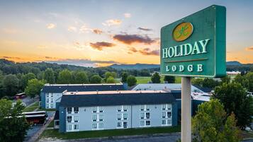 A Holiday Lodge sign with a view of the building and surrounding landscape.