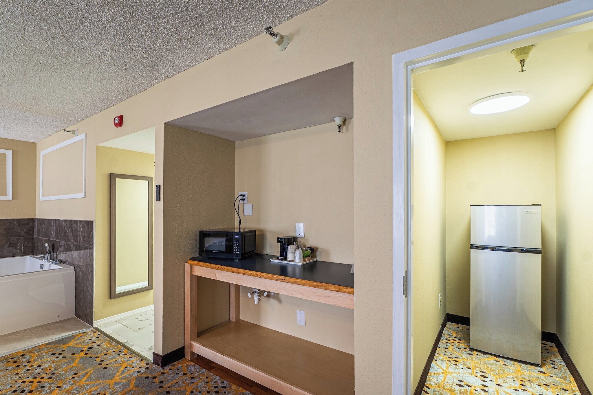 Una camera d'albergo con bagno, angolo cottura e pavimento decorato.