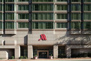A multi-story building with a prominent red logo on the facade, large windows, and a symmetrical design. - Durham Marriott City Center (Durham)