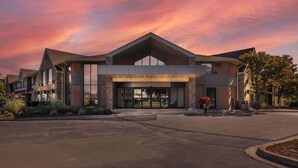 A modern hotel with a prominent entrance, large windows, and a landscaped driveway. - Comfort Inn Burlington (Burlington)