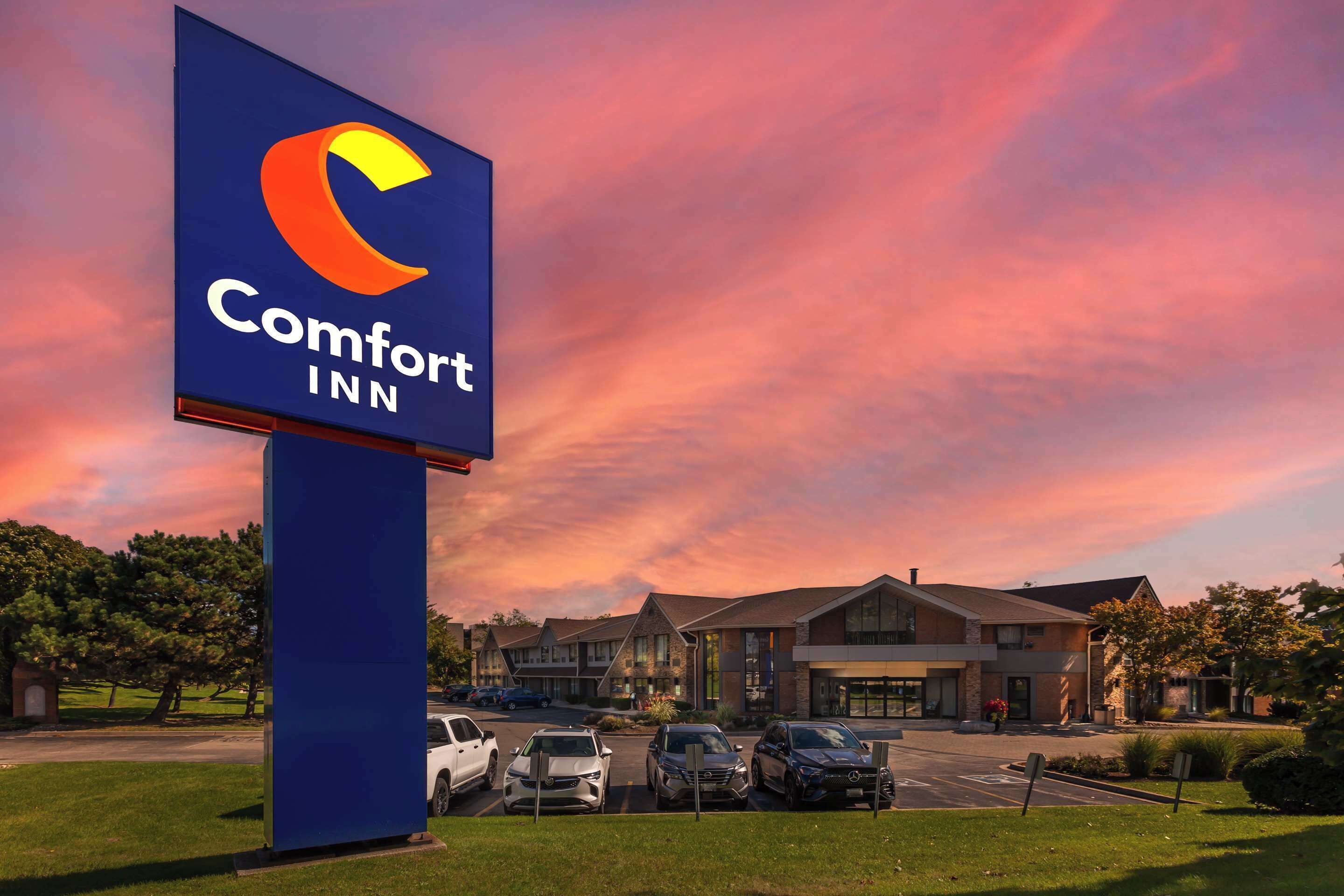 A Comfort Inn sign with a parking lot and hotel buildings in the background.