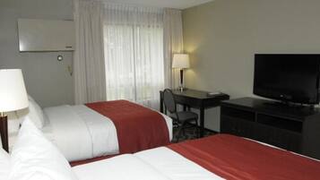 Une chambre d’hôtel avec deux lits, un bureau, une chaise, une télévision et une fenêtre avec des rideaux.